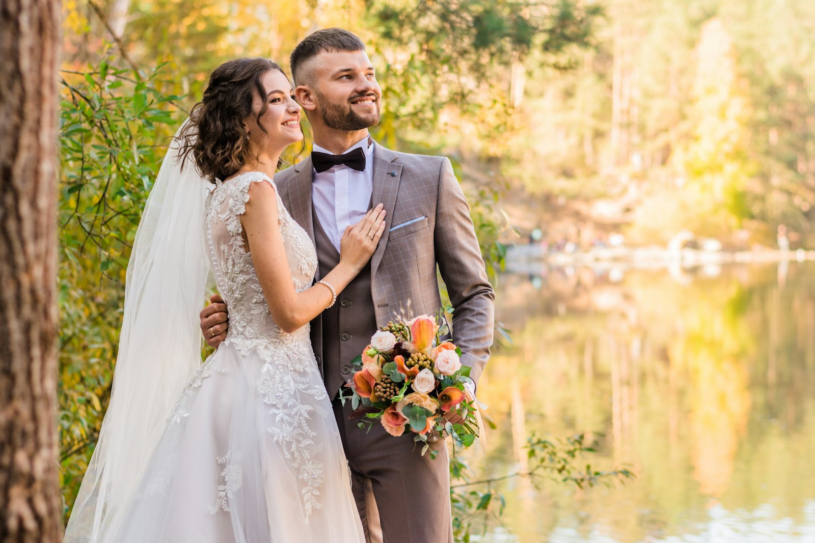 Bride and groom by a lake near Fort St. John in autumn